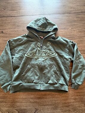 BROKEN PLANET- Green Graphic Zip-Up Hoodie with Raised Planet Design
